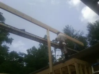 Carpenter setting a ridge beam over a new addition frame — Ice Dam Removal by Roofing Brothers in Lake Como
