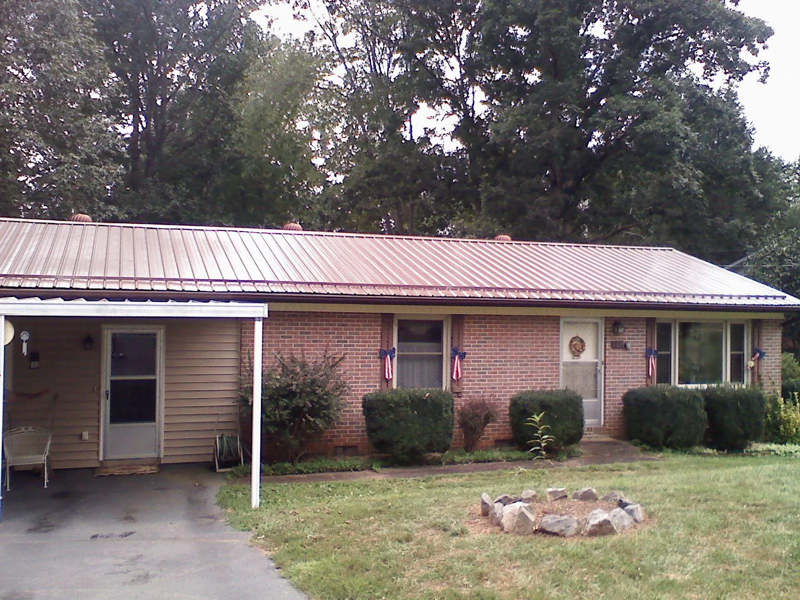 Bronze metal roof and carport on a brick ranch home — Roof Repair work by our crew in Lake Como